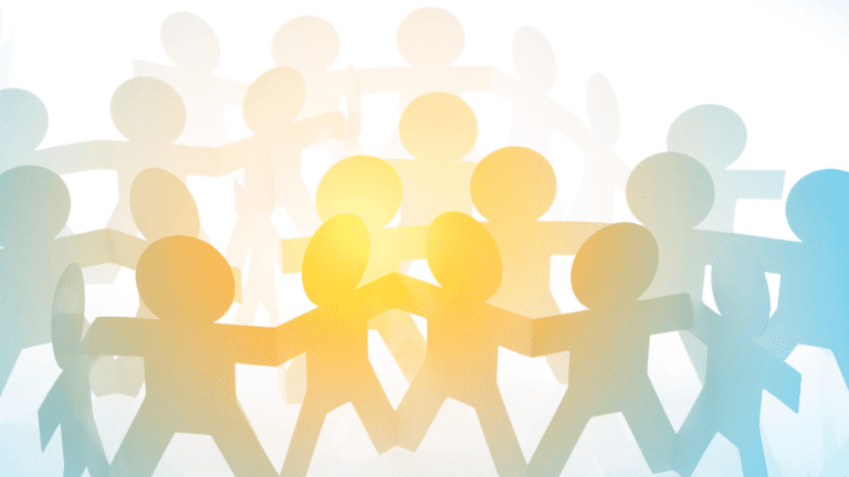 Stylized paper-cutout people holding hands form a circle, with yellow and blue light effects creating a warm, unified, and collaborative atmosphere that reflects employee integrity.
